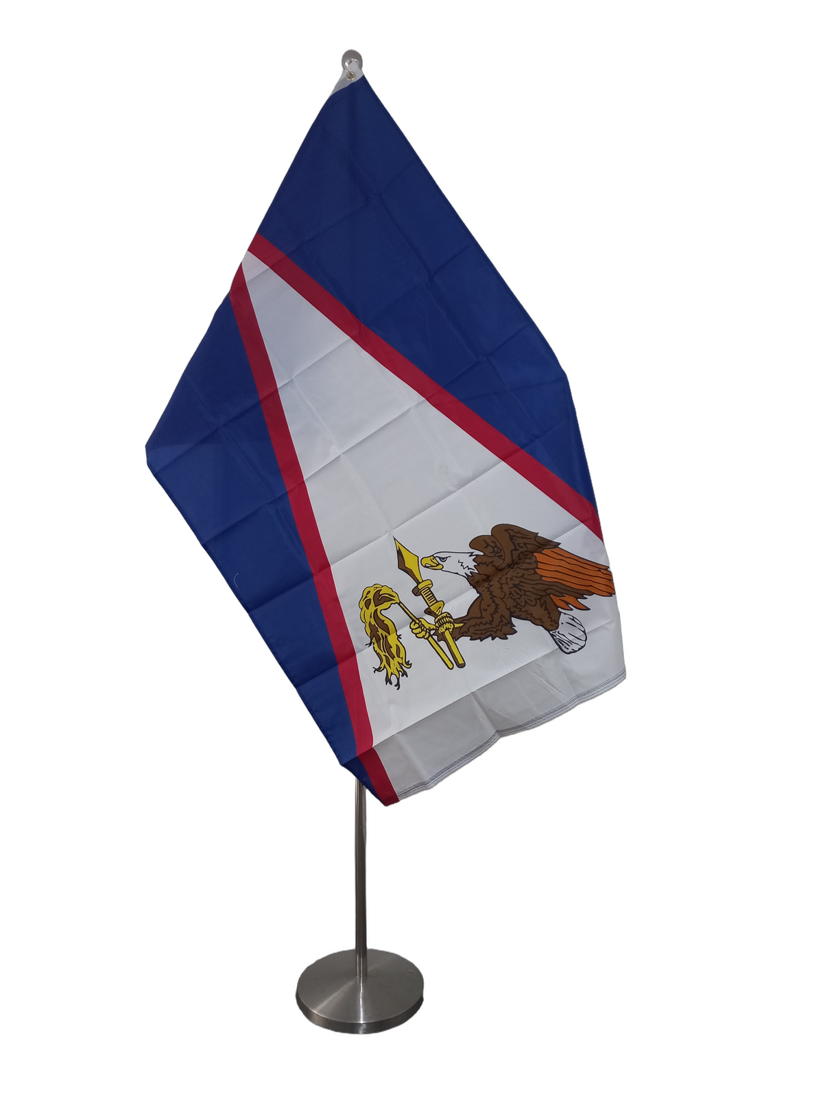 Flag of American Samoa featuring a white triangle with a red and blue stripe, containing an emblem with an eagle on a shield, two metal grommets for flying. On a ceremonial pole.