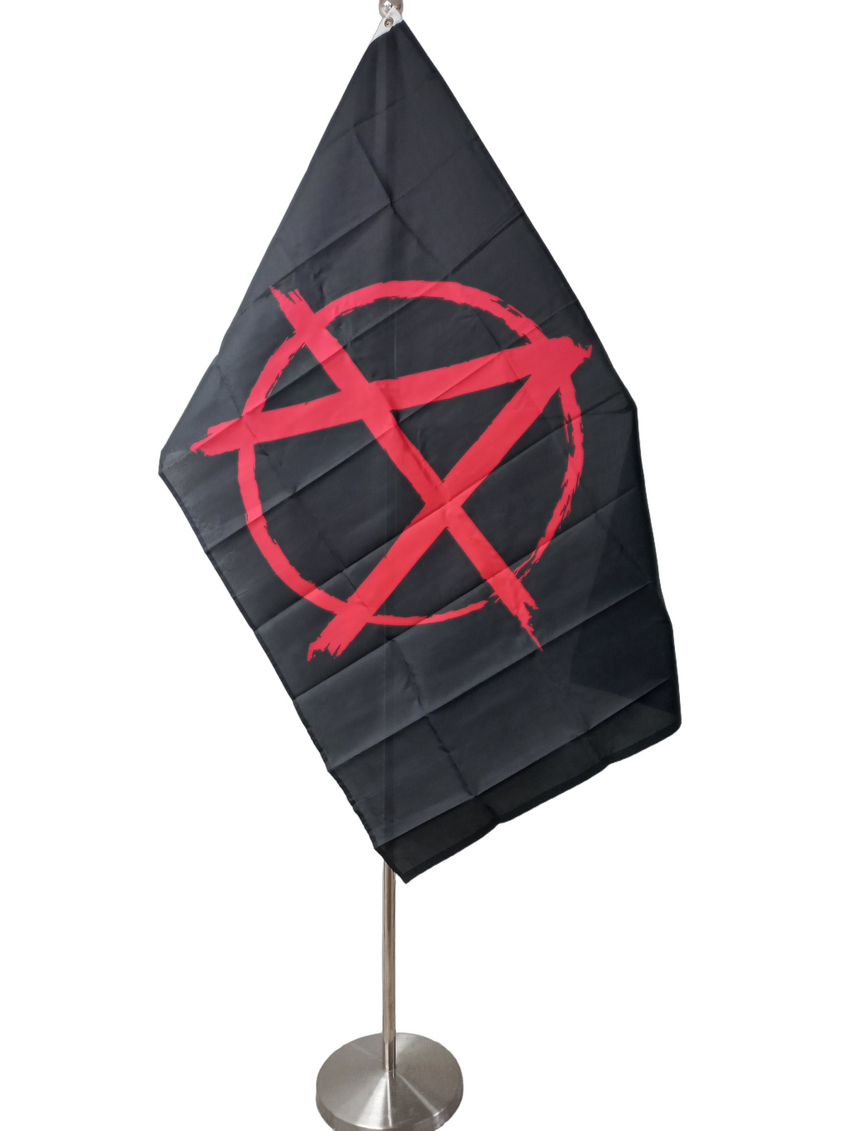 A flag with a black background and a red anarchy symbol in the center, with two metal grommets for flying. On a ceremonial pole.