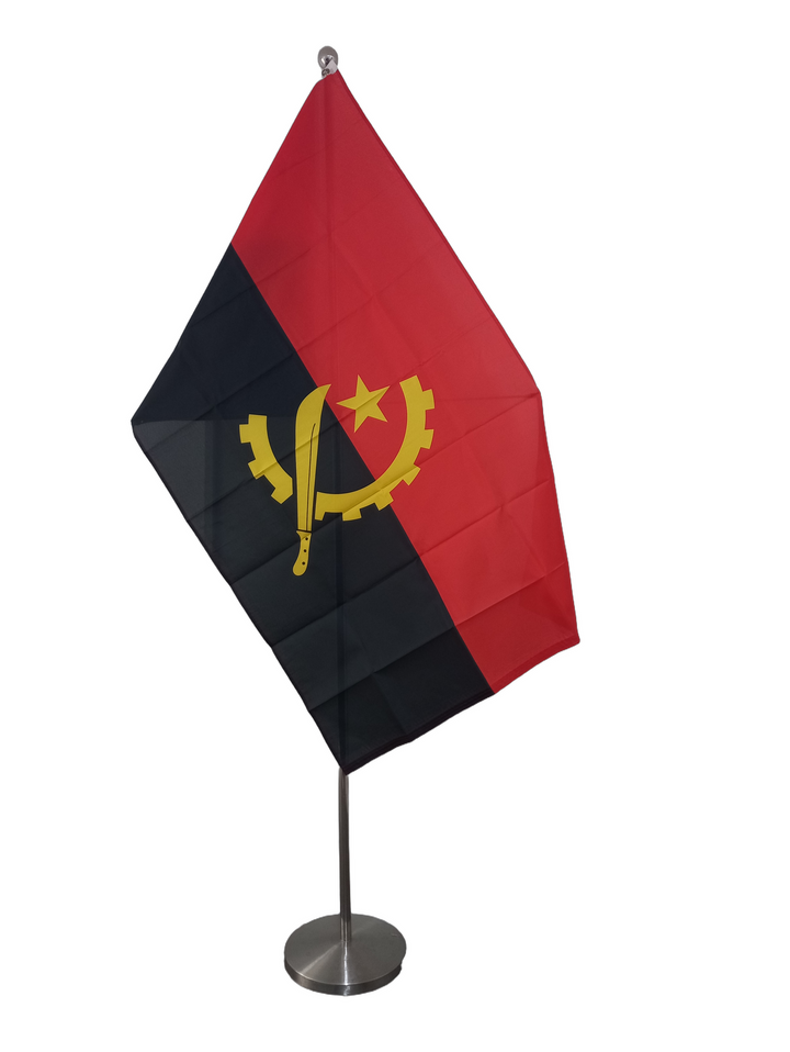 Flag of Angola with horizontal bands of red and black featuring a yellow emblem with a star and a sickle. On a ceremonial pole.