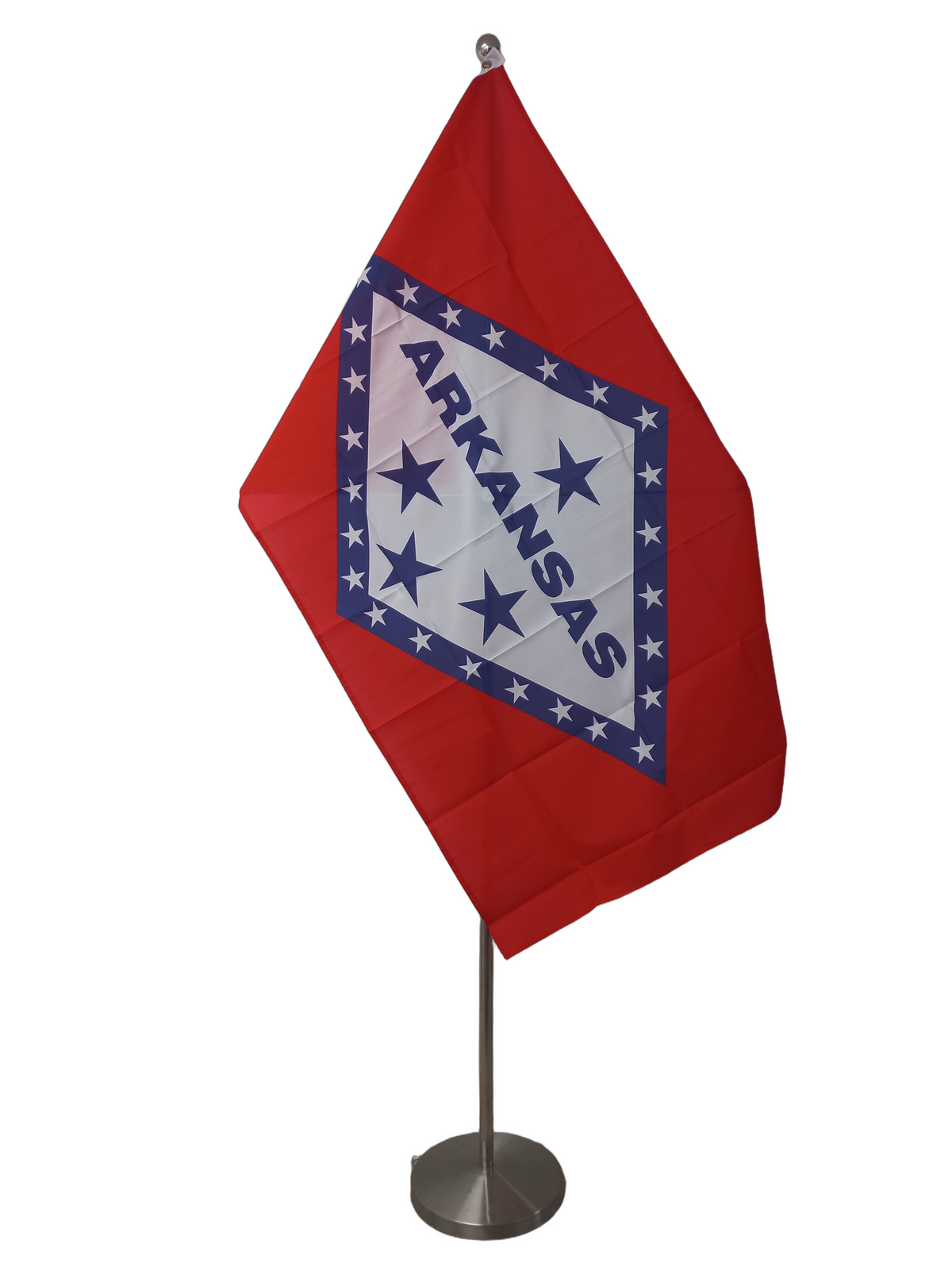 A rectangular flag of Arkansas with a red background, white stars, and the word 'ARKANSAS' in bold lettering. On a ceremonial flagpole.