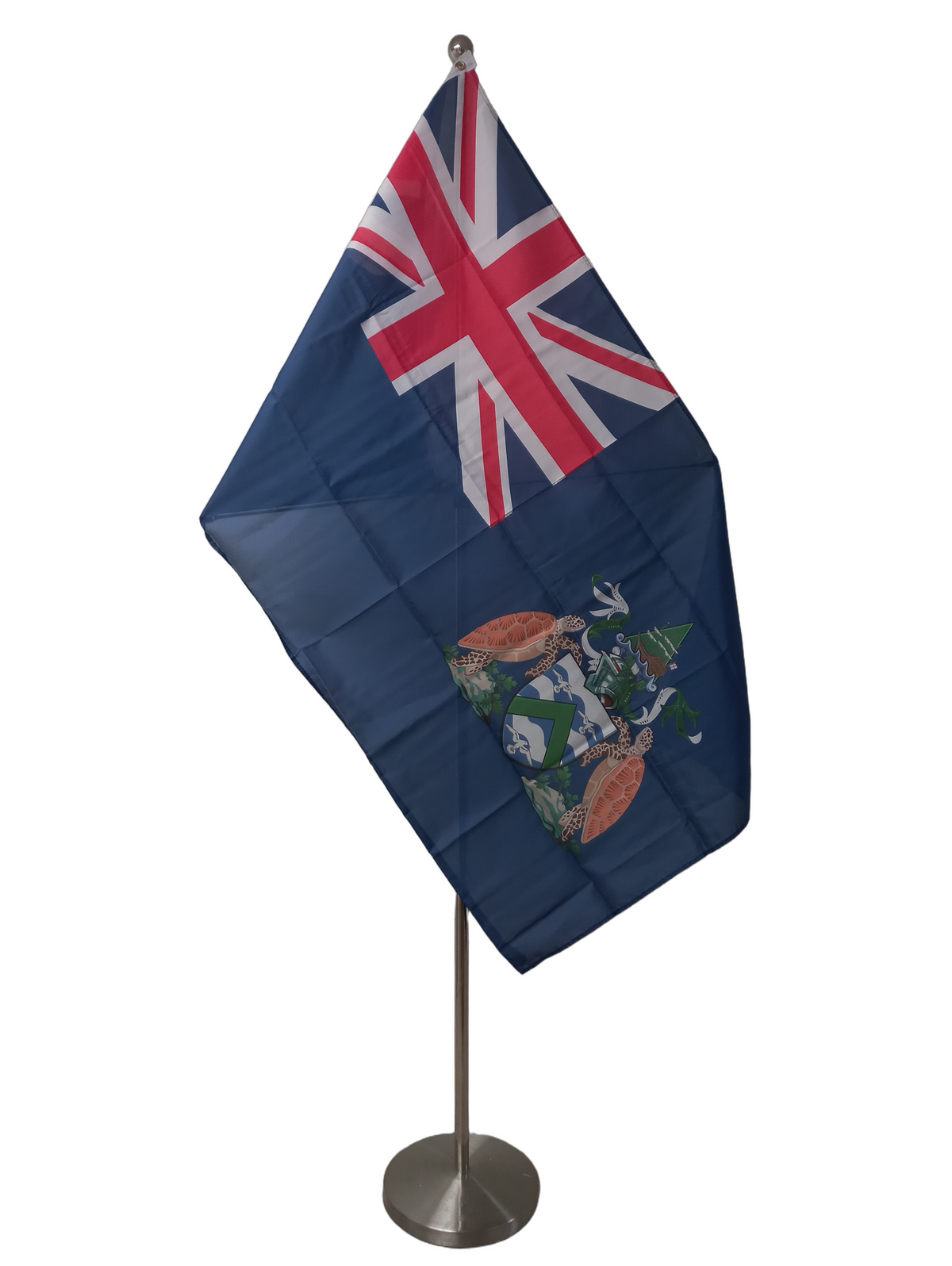 Flag of Ascension Island featuring the Union Jack and the coat of arms of Ascension Island on a dark blue background with two metal grommets for flying. On a ceremonial flagpole.