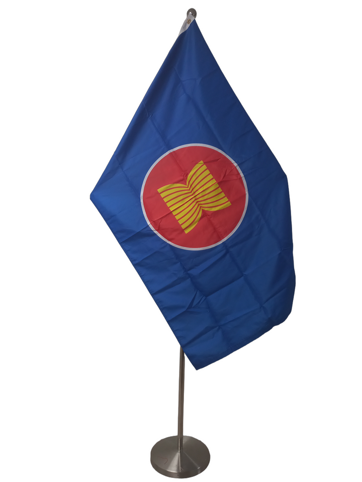 Flag of ASEAN - The Association of Southeast Asian Nations, with a blue field and a yellow circle featuring a golden symbol, on a 90 x 150 cm rectangle with two metal grommets. On a ceremonial flagpole.