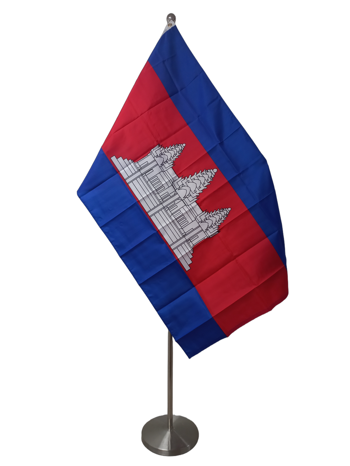 The flag of Cambodia, featuring a red and blue color scheme with a white and silver representation of the Angkor Wat temple complex on a red background. On a ceremonial flag pole.