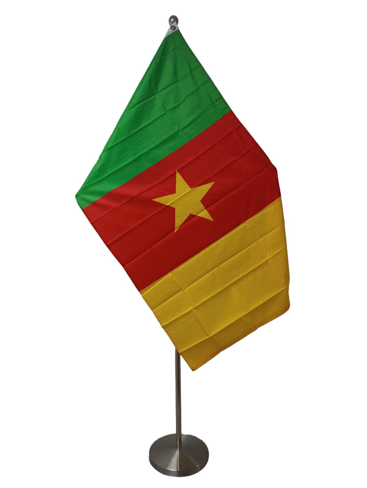 Flag of Cameroon, with vertical stripes in green, red, and yellow colors, featuring a yellow star on the red stripe. The flag has two metal grommets for flying. On a ceremonial flag pole.