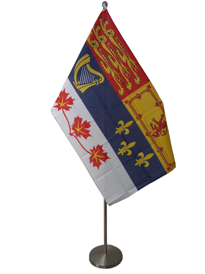 Royal flag of Canada with the rampant lion in the upper right corner, three lions on a red background on the upper right corner, below these two there is a blue stripe with a harp on the left and three stylized lilies on the right and below the blue stripe there is a white stripe with three maple leaves. On a ceremonial flag pole.