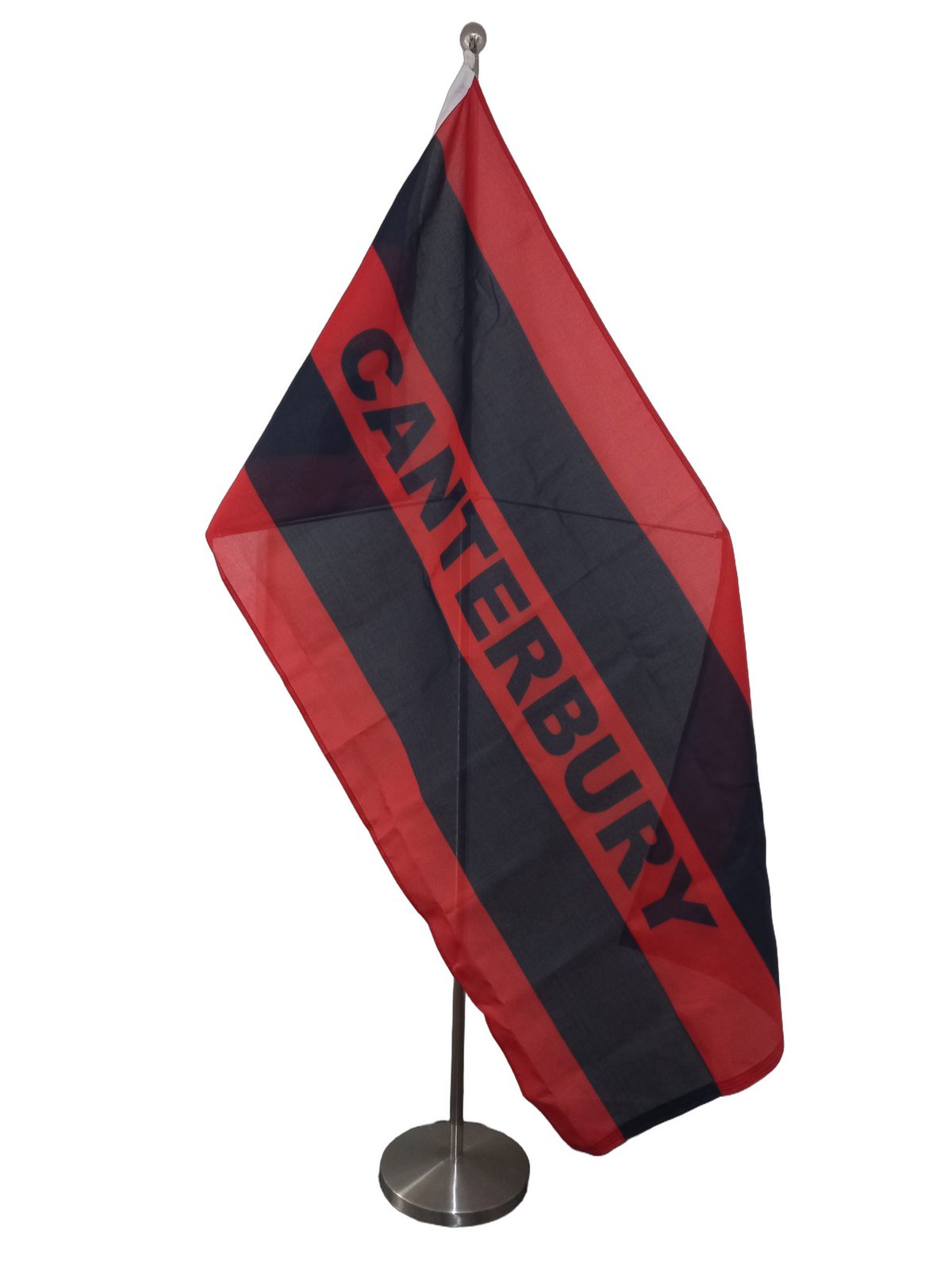 A red and black Canterbury flag with the name 'CANTERBURY' written across it. On a ceremonial flag pole.