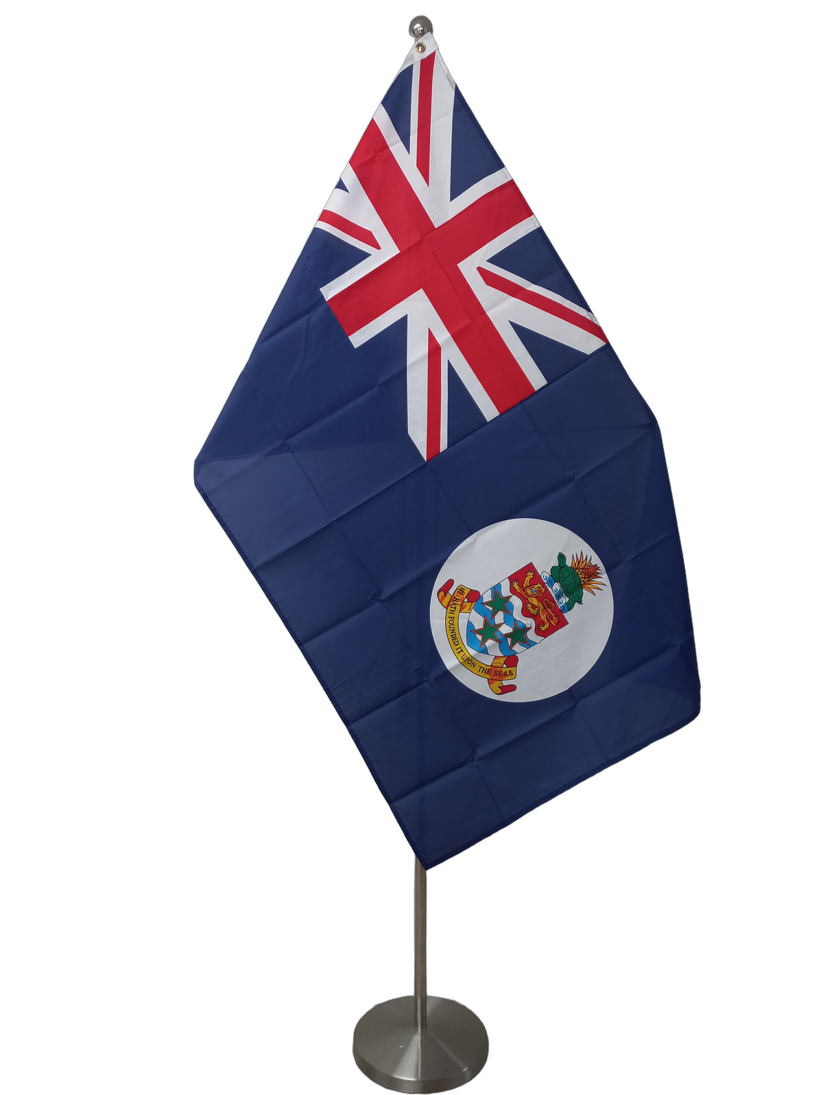 Flag of the Cayman Islands featuring a Union Jack canton with the Cayman Islands coat of arms on a white circle on a blue field. The flag has two metal grommets for flying. On a ceremonial flag pole.