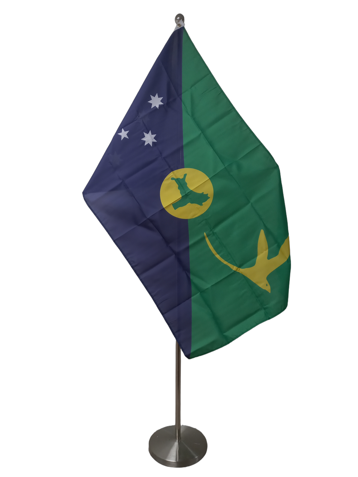 Flag of Christmas Island featuring a blue and green design with white stars, a yellow bird, and a gold and green emblem of the islands shape. On a ceremonial flag pole.