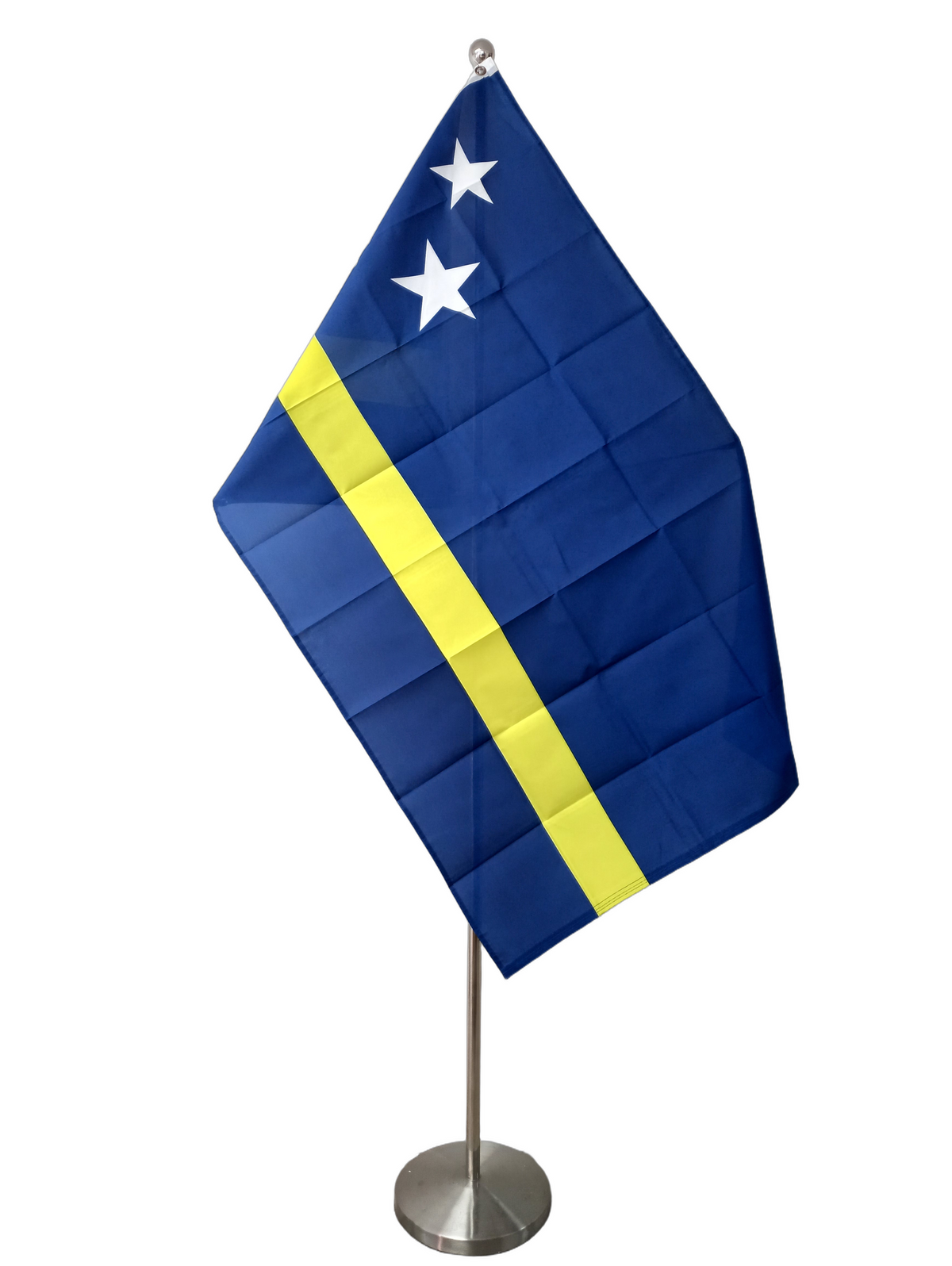 The flag of Curacao, featuring a blue background with a yellow horizontal stripe and a two white stars at the top left. On a ceremonial flag pole.