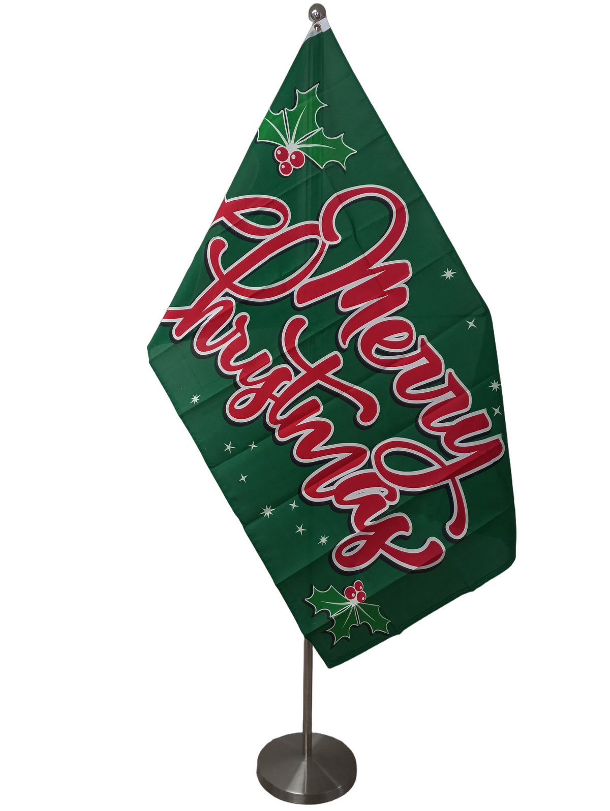 A green rectangular flag with the text 'Merry Christmas' in red script, surrounded by holly leaves and berries, also in red.